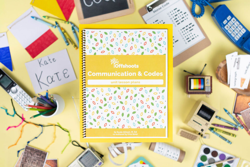 Overhead shot of a curriculum flat lay set on a yellow background with different methods of communication, from Greek letters to ciphers, Morse code and an old telephone.